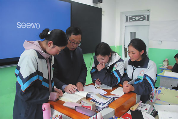འདི་ནི་ཧྲང་ཧའེ་ཡི་མཚོ་སྐྱོར་ལས་བྱེད་པ་མགོ་ལོག་ཀྲོའུ་ཟི་ལིང་མི་རིགས་སློབ་འབྲིང་གི་དགེ་རྒན་ལུའོ་ཐེན་ཧྭ་ཡིས་སློབ་མར་དཀའ་གནད་གསལ་འགྲེལ་བྱེད་བཞིན་པ།