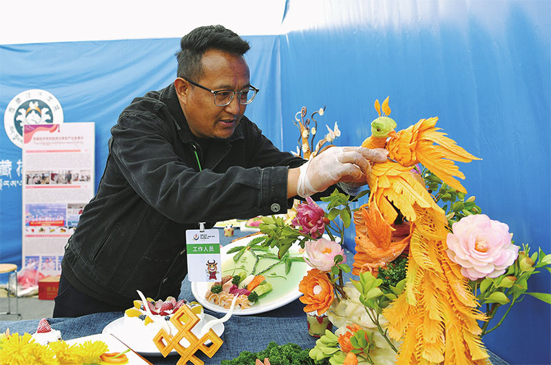 འདི་ནི་བོད་ཀྱི་ལག་རྩལ་སློབ་གླིང་གི་དགེ་རྒན་ཞིག་གིས་ཟས་རིགས་བརྐོས་བཀྲོལ་གྱི་སྒྱུ་རྩལ་བརྩམས་ཆོས་སྟོན་བཞིན་པ།