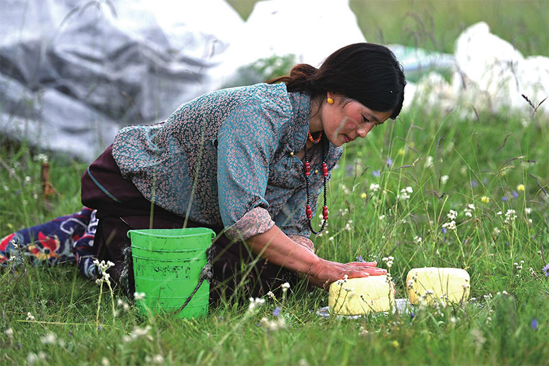 འདི་ནི་བཀྲ་ཤིས་ཆོས་འཕེལ་གྱི་བཟའ་ཟླ་གདུགས་དཀར་སྐྱིད་ཀྱིས་མར་གདར་བཟོ་བཞིན་པ།